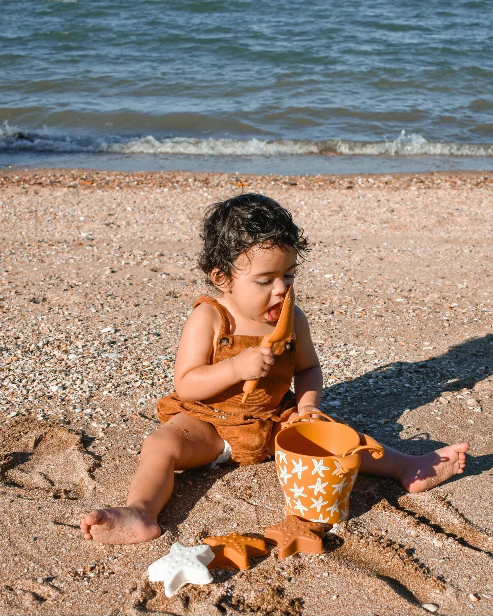 a child playing with beach toys on a holiday