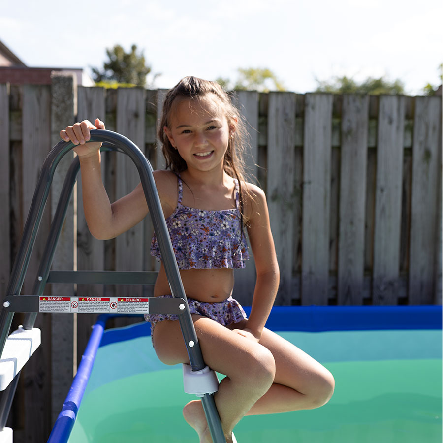child on stairs of frame pool